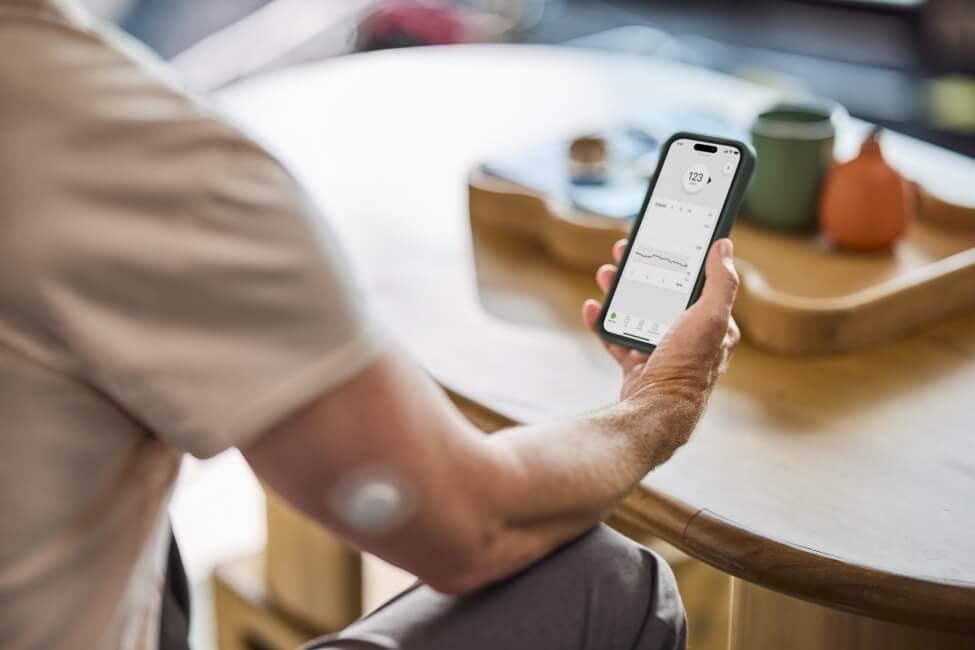 Lance wearing Dexcom G7 CGM sensor on his arm and checking his readings on his phone.